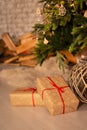 New year`s gifts and wicker basket under beautiful Christmas-tree with fireplace hearth and grey brick wall background. Royalty Free Stock Photo