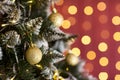 New Year`s green fir-tree, spheres gold, a red background, a wall with small lamps. New Year`s mood Royalty Free Stock Photo