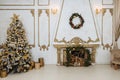 New Year`s interior with a decorated Christmas tree and a fireplace in the living room in white tones,New Year`s gifts lie under Royalty Free Stock Photo