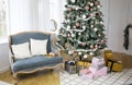 New Year`s interior with ÃÂhristmas-tree decorations, balls and lights. Gifts under the tree. Comfortable blue sofa with pillows Royalty Free Stock Photo