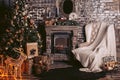 New Year`s interior with a warm fireplace, a Christmas tree and decorative elements in dark colors