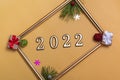 New Year`s layout on a beige background: Christmas balls, branches of a Christmas tree, a gift box and a gold frame, a mockup of Royalty Free Stock Photo