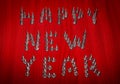 New Year`s layout for the carpenter. On a wooden surface in red, the text Happy New Year is lined with screws