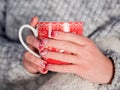 New Year`s mug in female hands with beautiful New Year manicures
