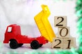 2021 new year`s number on wooden blocks that are unloaded by a toy dump truck Royalty Free Stock Photo