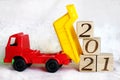 2021 new year`s number on wooden blocks that are unloaded by a toy dump truck on white background Royalty Free Stock Photo