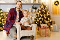 New Year`s photo of father hugging son sitting on armchair Royalty Free Stock Photo
