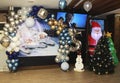 New Year`s photo zone with shiny balloons, a green Christmas tree and a figure of Santa Claus