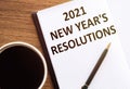 2021 NEW YEAR`S RESOLUTIONS text on notepad on wooden desk Royalty Free Stock Photo