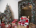 New Year`s scenery indoors. The decorated green Christmas tree. It is a lot of gifts. A zone with a pillow and a red bear