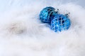 New years still life: for a postcard, two blue Christmas balls on a white Swan`s down, Royalty Free Stock Photo