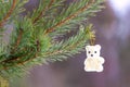 New Year`s toy white teddy bear hangs on a branch of a Christmas tree in the woods Royalty Free Stock Photo