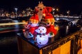 New Year`s toys snowmen and deer pose against night canals of Amsterdam.n