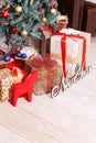 The New Year`s tree decorated with spheres and a garland, gifts, the inscription `New Year` and a red figurine of a horse