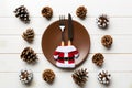 New Year set of plate and utensil on wooden background. Top view of holiday dinner decorated with pine cones. Christmas time Royalty Free Stock Photo