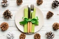 New Year set of plate and utensil on wooden background. Top view of holiday dinner decorated with pine cones. Christmas time Royalty Free Stock Photo