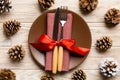 New Year set of plate and utensil on wooden background. Top view of holiday dinner decorated with pine cones. Christmas time Royalty Free Stock Photo