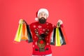New year shopping festival. Hipster hold shopping bags. Bearded man enjoy holiday shopping. Brutal shopper red