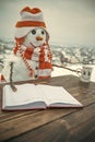 New year snowman from snow in hat read book.