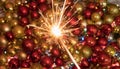 New year sparkler lighting up amazing red yellow and gold decorative balls Royalty Free Stock Photo