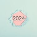 New year 2024 stands behind ripped paper, calendar date, end of the year, changing time, New Year\'s Eve holiday