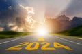 New year 2024 or straight forward concept. Text 2024 was written on the road in the middle of the asphalt road at sunset. Concept