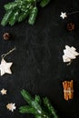 New year symbols. Spruce branch, cones and toys for decoration like spruce and stras on black background top view space