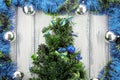 New year theme christmas tree with blue and green decoration and silver balls on white stylized wood background