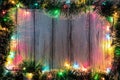 New year theme: christmas tree decoration and garland with colored lights on white stylized wood background Royalty Free Stock Photo