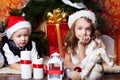 New year time. Happy childrens with cristmas presents near the fur-tree