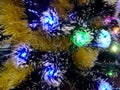 New Year tinsel with neon lights on a Christmas tree closeup Royalty Free Stock Photo