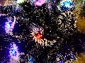 New Year tinsel with neon lights on a Christmas tree closeup Royalty Free Stock Photo