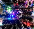 New Year tinsel with neon lights on a Christmas tree closeup