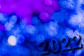 New Year, 2022. Translucent numbers of the year on a blue-toned background of bright lights out of focus. Horizontal design. Royalty Free Stock Photo