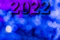 New Year, 2022. Translucent numbers of the year on a blue-toned background of bright lights out of focus. Horizontal design. Royalty Free Stock Photo