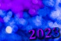 New Year 2023. Translucent numbers of the year on a blue-toned background of bright lights out of focus. Horizontal design Royalty Free Stock Photo