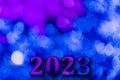 New Year 2023. Translucent numbers of the year on a blue-toned background of bright lights out of focus. Horizontal design.