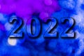 New Year, 2022. Translucent numbers of the year on a blue-toned background of bright lights out of focus. Horizontal design. Royalty Free Stock Photo