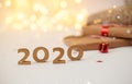 2020 New year wood number with sparkling festive christmas lights bokeh and falling snow