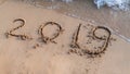 New Year 2019 written on sand beach and ocean wave. lettering on the beach. Happy New Year 2020 20121 Royalty Free Stock Photo