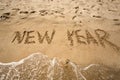 New Year written on sand and being washed by waves Royalty Free Stock Photo