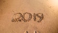 2019 New Year written on wet sand on the ocean beach. Concept of winter holidays, Christmas and tourism Royalty Free Stock Photo