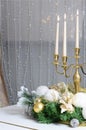 New Year& x27;s decorations and a golden candlestick with burning candles stand on the surface of a white grand piano