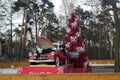 New Year's decorations in Pekhorka park. Artificial red pine tree and red old timer GAZ-M20 Pobeda delivering gifts.