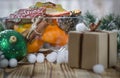 New year& x27;s gift stands on a wood table next to the oranges, tangerines, snowflakes and Christmas Toys