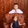 New Year xmas child. Christmas eve holiday. Brother and sister. Big chair. Blue dress. Small children Royalty Free Stock Photo