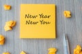 NEW YEAR NEW YOU word on yellow note with pen and crumbled paper on wooden table background. Resolutions, Strategy and Goal Royalty Free Stock Photo