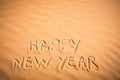 Happy New Year background. Handwriting in tropical sand. Royalty Free Stock Photo