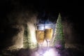 New Years Eve celebration background with pair of flutes and bottle of champagne with christmas tree on snow on dark background. Royalty Free Stock Photo