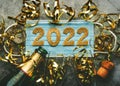 New Years Eve celebration concept background.Medical mask with the numbers 2022 and Champagne bottle with glasses .Covid-19 New Royalty Free Stock Photo